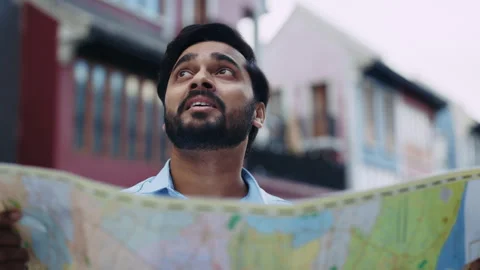 Portrait of bearded Indian man with map looks at landmarks of city outdoors Stock Footage 318722818