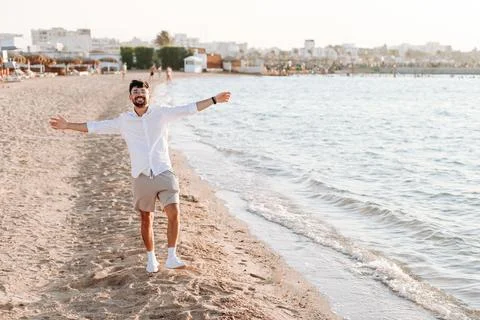 A portrait of a bearded lucky guy posing on an amazing tropical beach on a .. Stock Photos