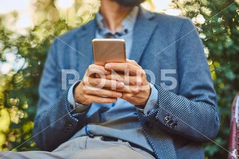 Portrait of a bearded male with a stylish haircut in casual clothes, writes a Stock Photos