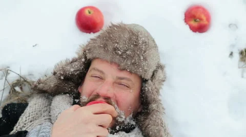 Portrait of a bearded man with an apple in the winter. Stock Footage 59603811