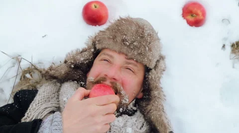 Portrait of a bearded man with an apple in the winter. Video stock 59606671