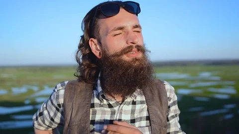 Portrait of a bearded man on a background of a beautiful landscape at sunset Stock Footage 89617931