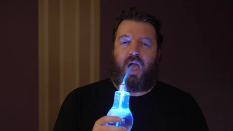 Portrait of bearded man with colored glowing fun party cocktail 스톡 동영상 122505073