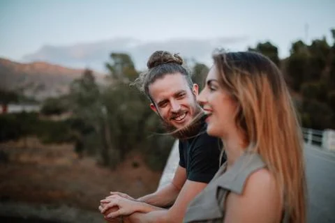 Portrait of bearded man laughing while look at her girlfriend in nature. Stock Photos