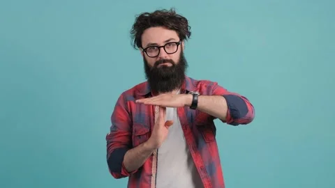 Portrait of a bearded man making the time out gesture, asking for a break. Stock Footage 139874081
