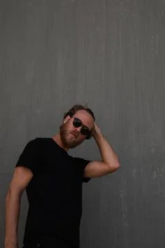 Portrait of bearded man posing over dark background wears black t-shirt. Fotos de archivo