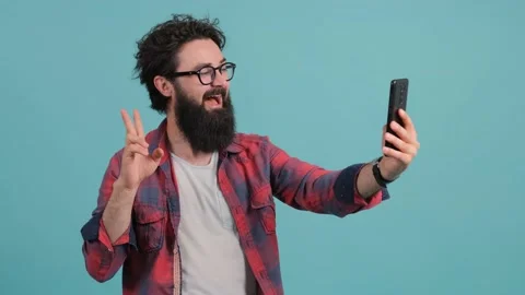 Portrait of a bearded man talking on video call and waving hand making hi Stock Footage 140188311