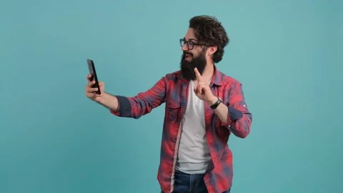 Portrait of a bearded man talking on video call and waving hand making hi Stock Footage 140616253