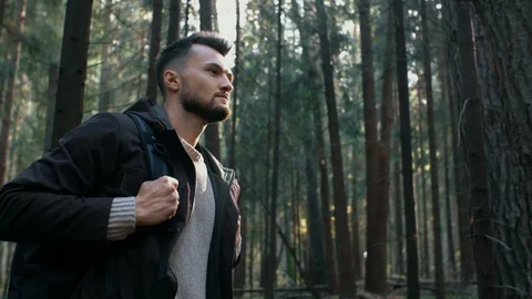 Portrait of bearded man walking through trees in forest, hiking in pine woodland Stock Footage 119044177