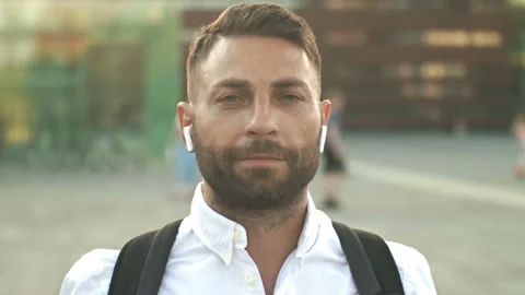Portrait of a bearded middle-aged man with wireless headphones in his ears. Stock Footage 197481219