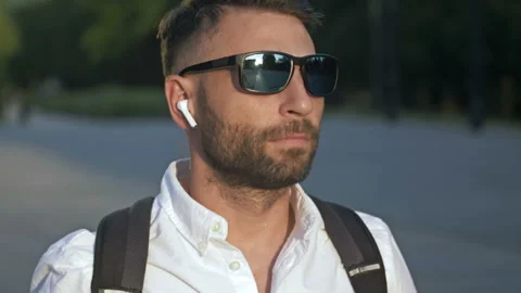 Portrait of a bearded middle-aged man with wireless headphones in his ears. Stock Footage 198565187