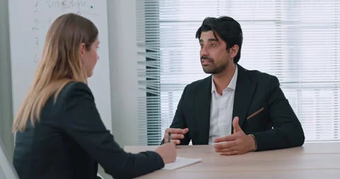 Portrait of bearded Middle Eastern man candidate talks to woman HR in office Видео 347831719