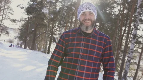 Portrait of a bearded smiling man in a winter forest looking at the camera Stock Footage 87205477