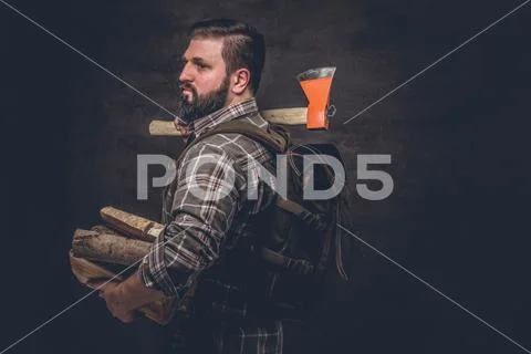 Portrait of a bearded woodcutter with a backpack dressed in a plaid shirt Stock Photos