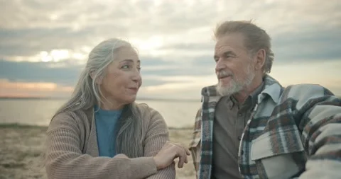 Portrait of beautiful bearded grey-haired grandfather sitting on beach talking Stock Footage 222997497