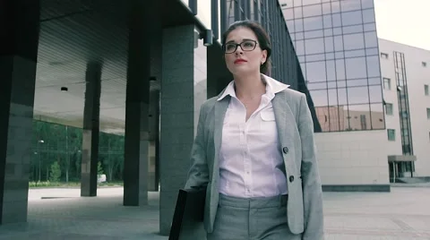 Portrait of beautiful business woman walking confidently to the office building Stock Footage