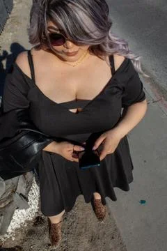 Portrait of beautiful chubby model using cell phone. Mexican woman Fotos Stock