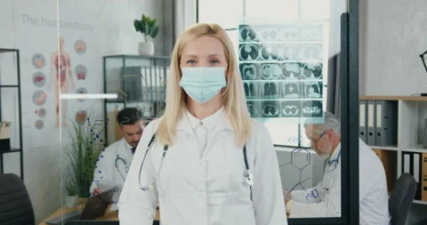 Portrait of beautiful confident high-skilled blond female doctor in protective Stock Footage 160473563