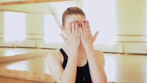 Portrait of a beautiful dancer making picaboo and smiling to the camera in the Stock Footage 76125501