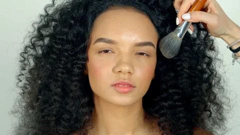 Portrait of beautiful , dark haired model, a make-up artist applies face powder Stock-Footage 88860610