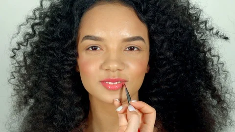 Portrait of a beautiful dark-haired model, who put a shiny lipstick on the lips Video stock 88860842