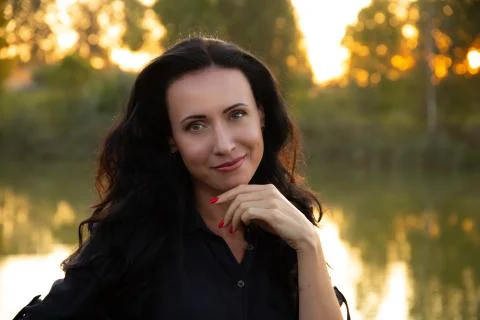 Portrait of a beautiful dark-haired young woman, girl on a background of summ Stock Photos