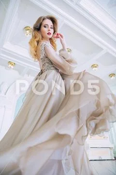 A portrait of a beautiful elegant woman in the fluttering wedding dress. Fash Stock Photos