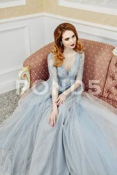 A portrait of a beautiful elegant woman in the wedding dress on the couch. Fa Stock Photos
