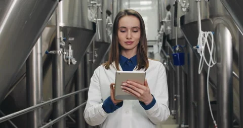 Portrait of beautiful female process engineer entering data on tablet at brewery Stock Footage 131297174