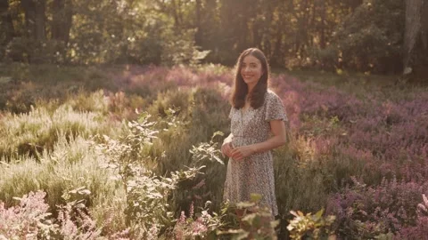 Portrait of a beautiful girl looking at the camera in a field of wildflowers. Video stock 281863629