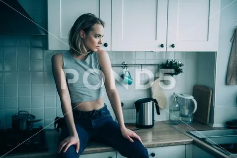 A portrait of a beautiful girl posing in the kitchen. Fashion, interior. Stock Photos