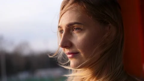 Portrait of a beautiful girl in the rays of the setting sun. Blonde girl Stock Footage
