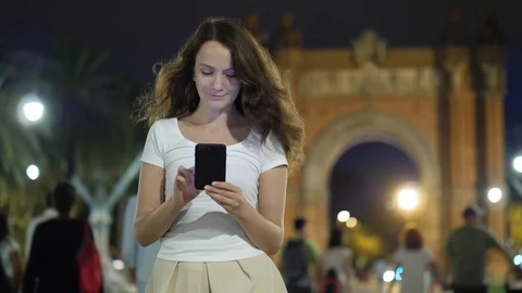 Portrait of beautiful girl using cell phone in Barcelona at night. Stock Footage 99007301
