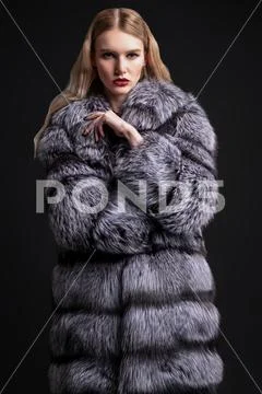 A portrait of a beautiful girl wearing a fur coat. Beauty, winter fashion. Stock Photos