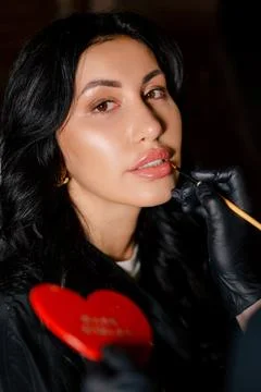 Portrait of the Beautiful Lady While the Make Up Artist Applying Lipstick on Her Stock Photos