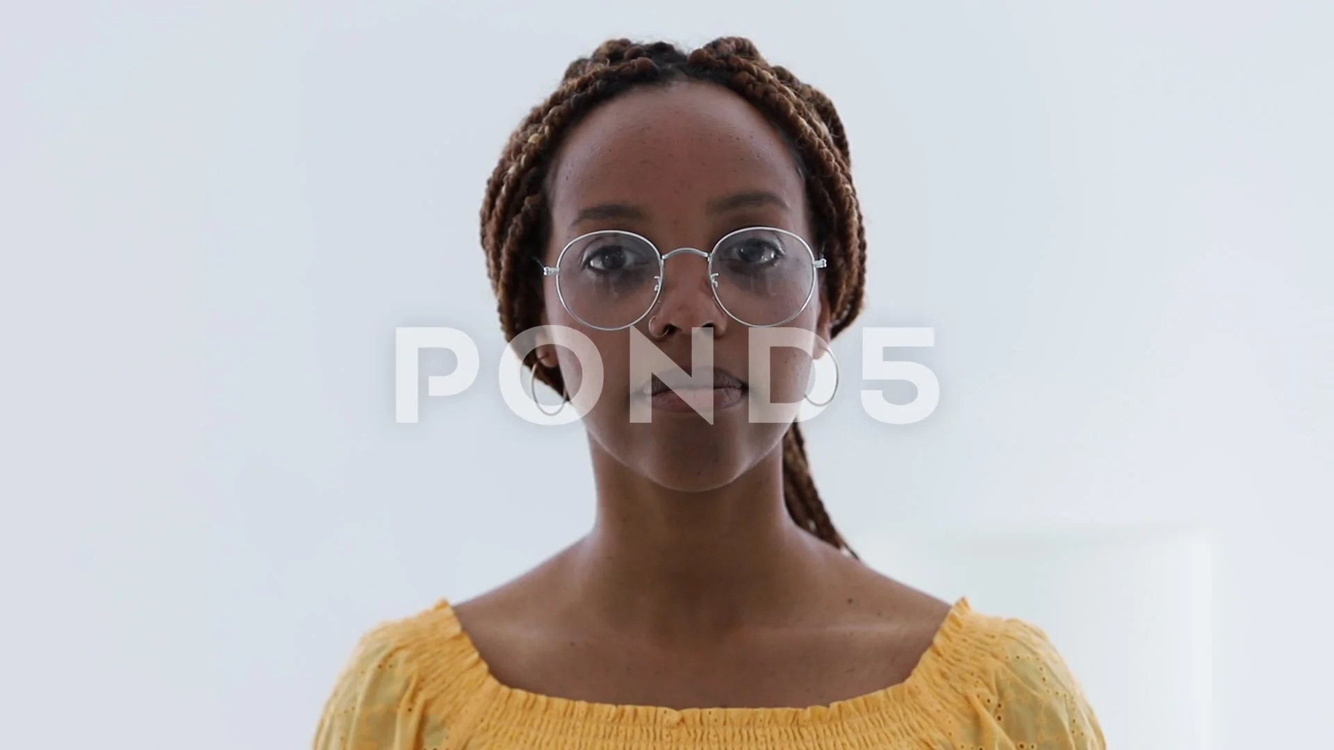 Portrait of beautiful mulatto woman posing for camera while standing in  light