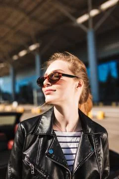 Portrait of beautiful smiling girl in black leather jacket and sunglesses Stock Photos