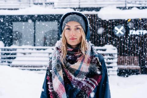 Portrait of a beautiful thirty-year-old European woman in a hood in a snowfall. Stock Photos