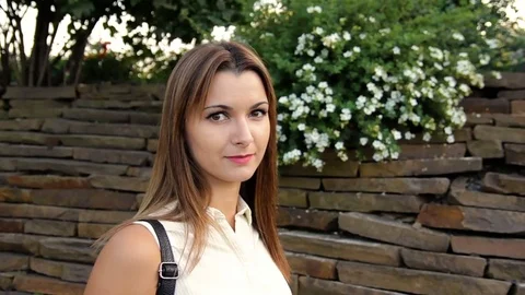 Portrait of the beautiful woman against the background of a wall from stones and Stock Footage