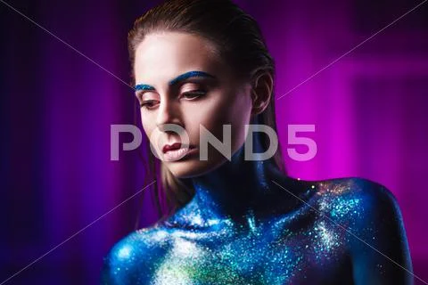 Portrait of beautiful woman painted with cosmic colors and spangled. Stock Photos