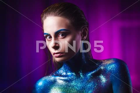 Portrait of beautiful woman painted with cosmic colors and spangled. Stock Photos