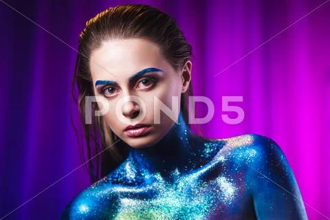 Portrait of beautiful woman painted with cosmic colors and spangled. Stock Photos