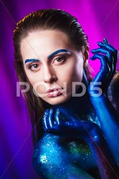 Portrait of beautiful woman painted with cosmic colors and spangled. Stock Photos