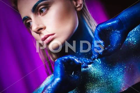 Portrait of beautiful woman painted with cosmic colors and spangled. Stock Photos