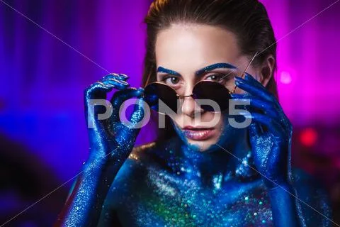 Portrait of beautiful woman painted with cosmic colors and spangled. Stock Photos
