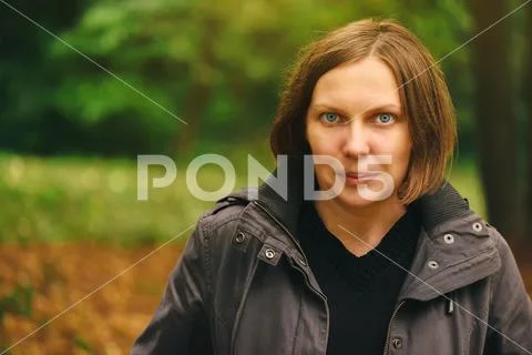 Portrait of beautiful young adult woman in autumn park Stock Photos