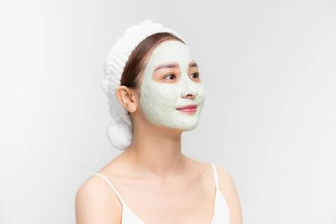 Portrait of beautiful young Asian woman with clay mask and towel on her hear Stock Photos