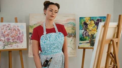 Portrait of beautiful young painter posing on camera in her art studio Stock Footage 74195515
