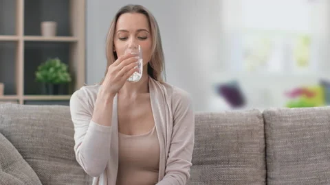 Portrait of beautiful young woman drinking refreshing pure water holding Stock Footage 155884953