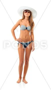 Portrait of a beautiful young woman posing in bikini, hat and sunglasses on w Stock Photos